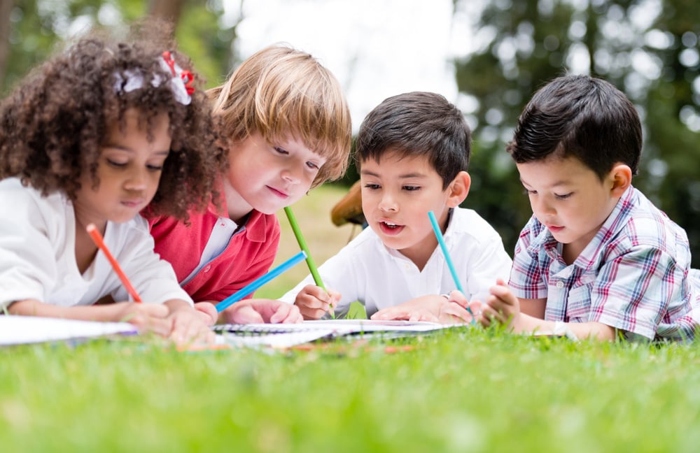 Group of school kids coloring outdoors looking happy